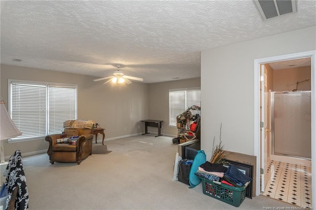 sitting room featuring visible vents, carpet floors, a healthy amount of sunlight, ceiling fan, and a textured ceiling