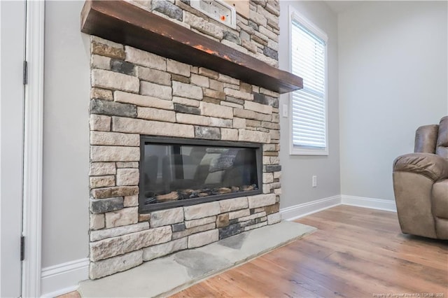 interior details with baseboards, a fireplace, and wood finished floors