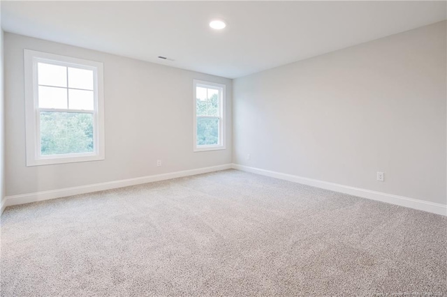 carpeted empty room with baseboards, recessed lighting, and visible vents