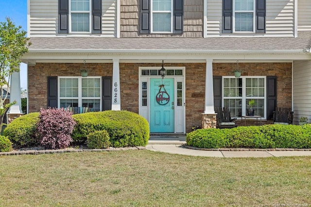 6628 Carriage Crossing Rd, Hope Mills, NC 28348 - doorway to property with a lawn, covered porch, and stone siding