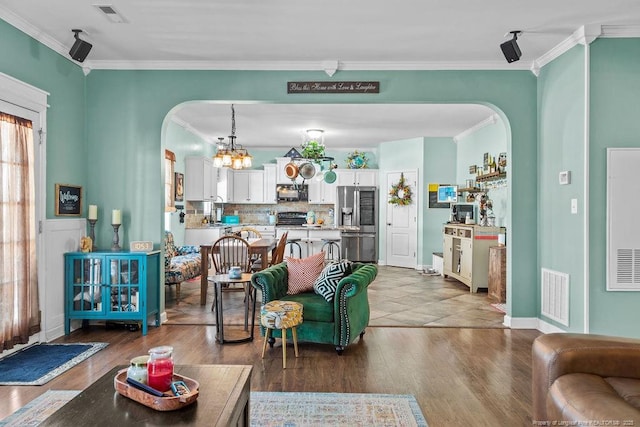 6628 Carriage Crossing Rd, Hope Mills, NC 28348 - living room with arched walkways, ornamental molding, wood finished floors, and visible vents