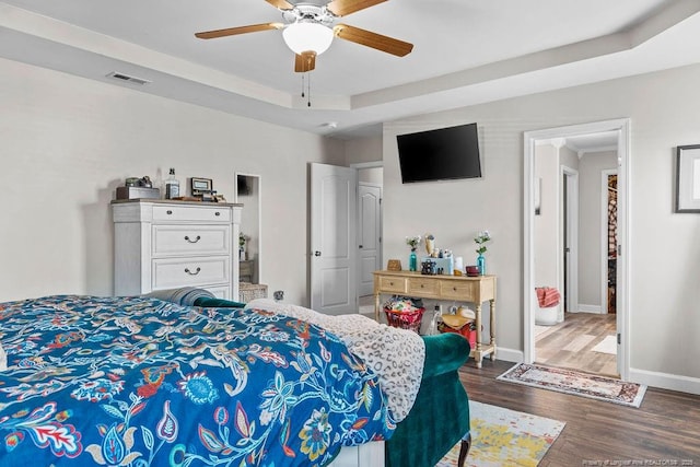 6628 Carriage Crossing Rd, Hope Mills, NC 28348 - bedroom featuring ceiling fan, baseboards, wood finished floors, a tray ceiling, and visible vents
