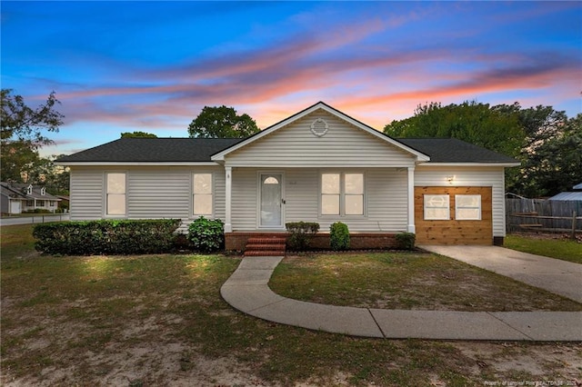 ranch-style house featuring a lawn, fence, and covered porch