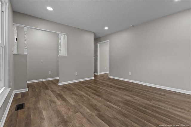 unfurnished bedroom featuring baseboards, dark wood finished floors, and visible vents