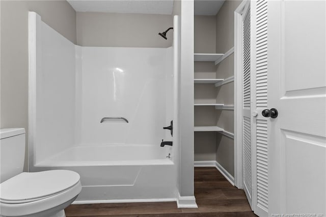 bathroom featuring shower / bathtub combination, a closet, toilet, and wood finished floors