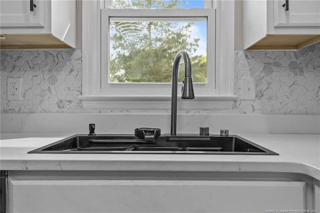details with light countertops, decorative backsplash, and a sink