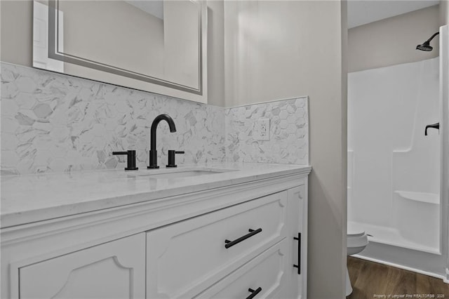 full bathroom with vanity, toilet, a shower stall, and tasteful backsplash