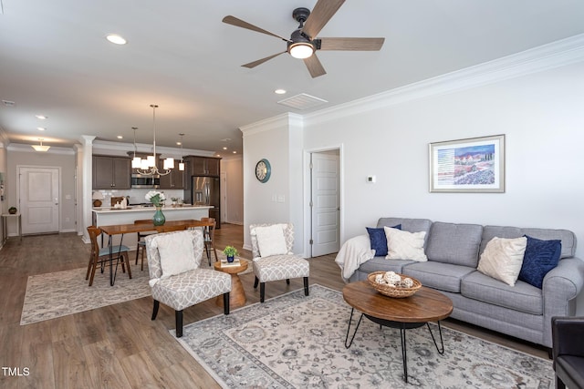 228 Shingle Oak Rd, Wake Forest, NC 27587 - living area with crown molding, a ceiling fan, wood finished floors, recessed lighting, and a chandelier