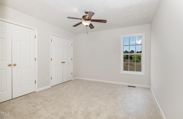 2919 Hayfield Rd, Wade, NC 28395 - unfurnished bedroom featuring baseboards, ceiling fan, visible vents, two closets, and carpet floors