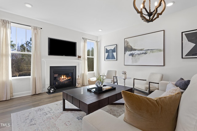 214 Alden Way, Angier, NC 27501 - living area with wood finished floors, a fireplace with flush hearth, a chandelier, and a wealth of natural light
