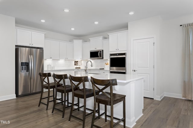 214 Alden Way, Angier, NC 27501 - kitchen with stainless steel appliances, an island with sink, tasteful backsplash, and dark wood-type flooring