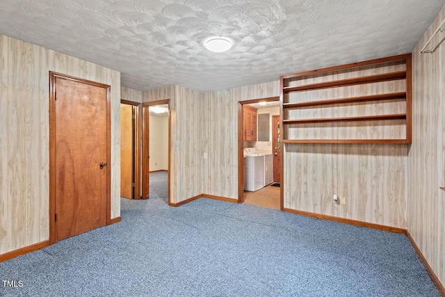 unfurnished bedroom with carpet floors, a textured ceiling, and baseboards