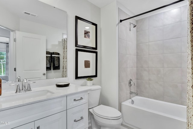bathroom featuring visible vents, toilet, shower / tub combo, and vanity