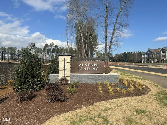 community / neighborhood sign featuring fence