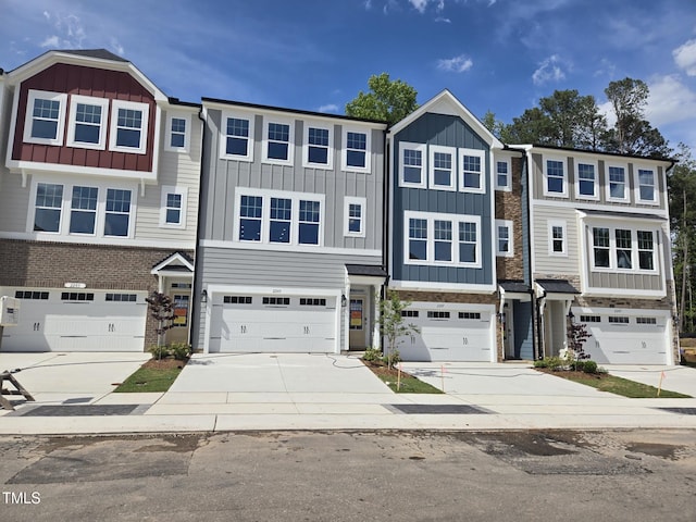 multi unit property featuring board and batten siding, driveway, and a garage