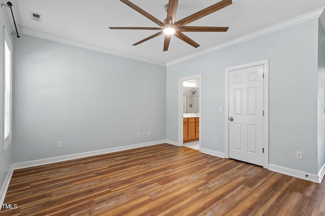 unfurnished bedroom featuring ensuite bathroom, visible vents, wood finished floors, baseboards, and ornamental molding