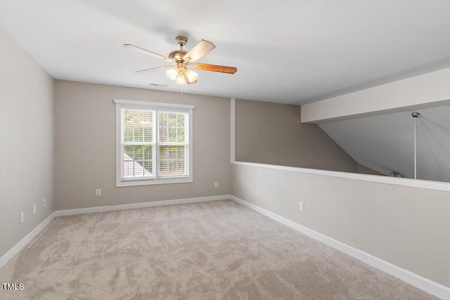 carpeted empty room with baseboards, a ceiling fan, lofted ceiling, and visible vents