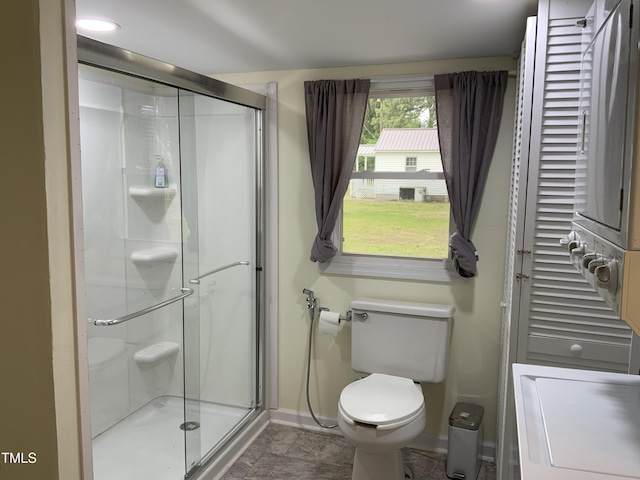 109 Revelle Park Ln, Murfreesboro, NC 27855 - bathroom with baseboards, a shower stall, toilet, and estacked washer and dryer