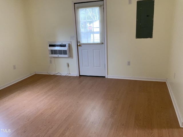 109 Revelle Park Ln, Murfreesboro, NC 27855 - empty room featuring electric panel, wood finished floors, baseboards, and a wall mounted air conditioner