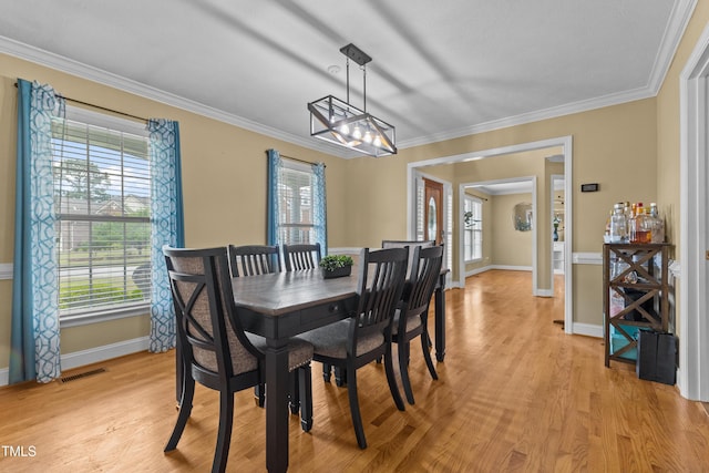dining area featuring light wood-style floors, baseboards, a notable chandelier, and a wealth of natural light