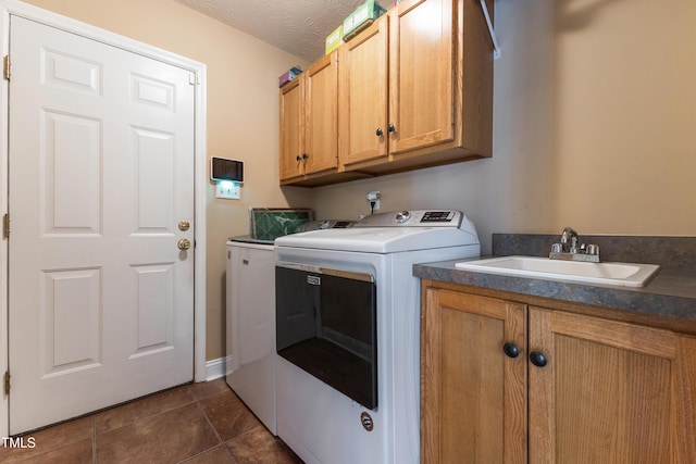 laundry room with independent washer and dryer, dark tile patterned floors, a sink, and cabinet space