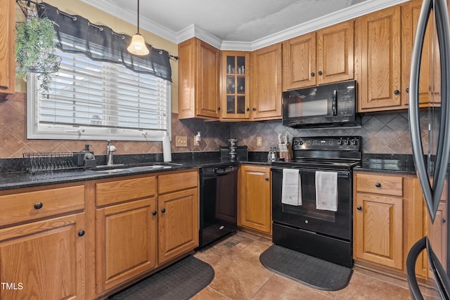 kitchen featuring crown molding, brown cabinetry, decorative backsplash, a sink, and black appliances