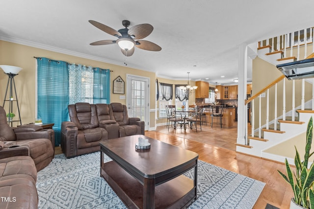 living room with ceiling fan with notable chandelier, stairs, recessed lighting, light wood-type flooring, and ornamental molding