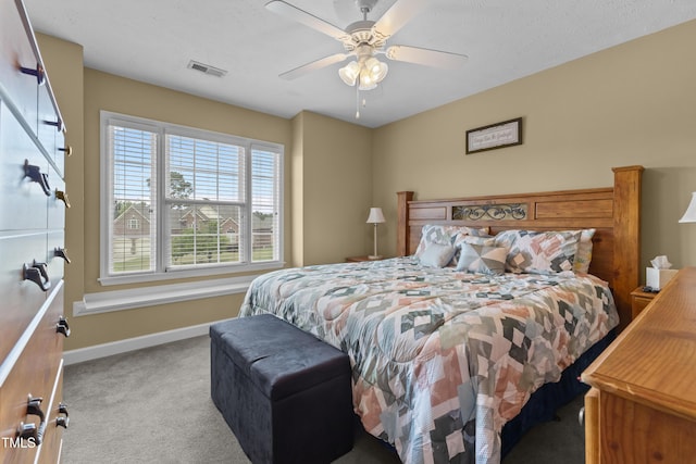 carpeted bedroom with baseboards, a ceiling fan, and visible vents