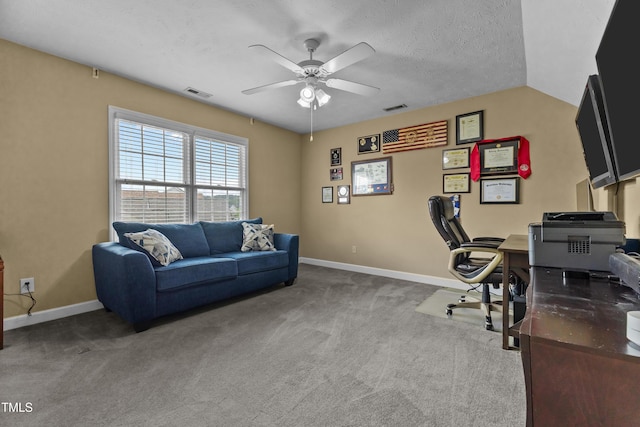 carpeted office space featuring ceiling fan, visible vents, and baseboards