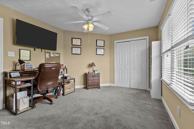 office area featuring carpet floors, ceiling fan, and baseboards