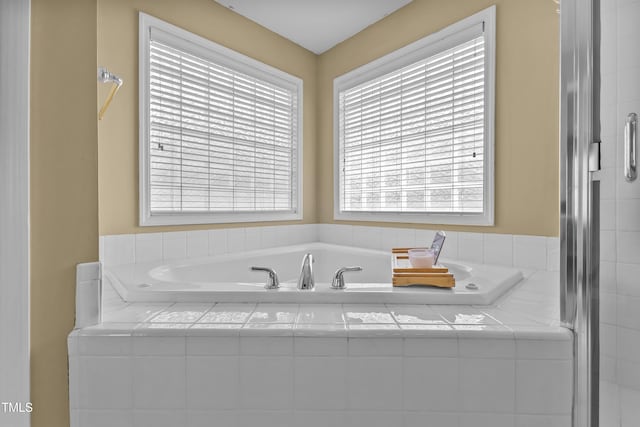 full bathroom featuring a shower with shower door and a bath