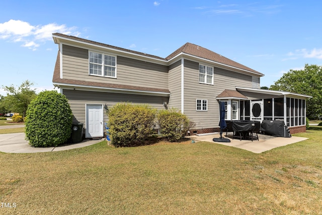 rear view of house with a lawn, a shingled roof, a patio area, and a sunroom