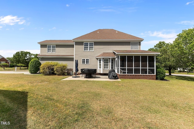 rear view of property with a yard, a patio, and a sunroom