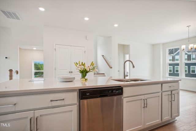 kitchen featuring a sink, light wood-style floors, light countertops, stainless steel dishwasher, and visible vents