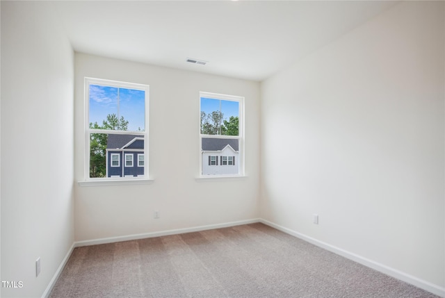 carpeted empty room with baseboards and visible vents