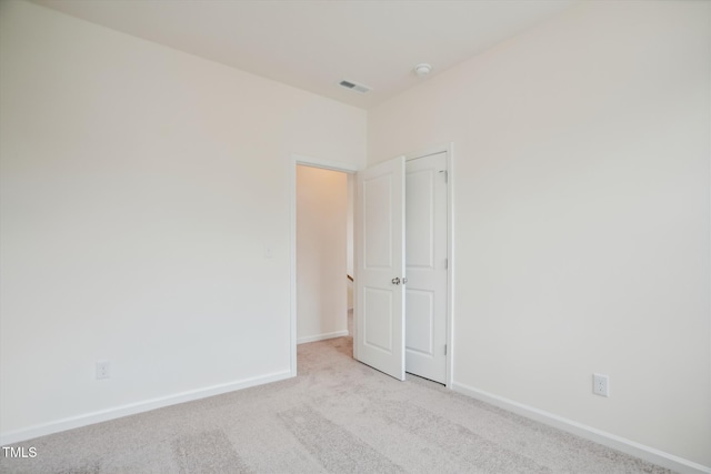 carpeted spare room with baseboards and visible vents