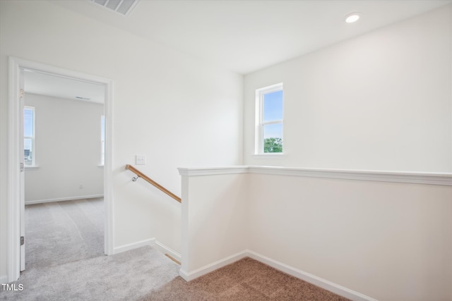 stairway featuring carpet floors, visible vents, and plenty of natural light