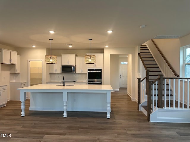 1024 Channel Drop, Zebulon, NC 27597 - kitchen with stainless steel appliances, white cabinetry, dark wood-type flooring, a center island with sink, and recessed lighting