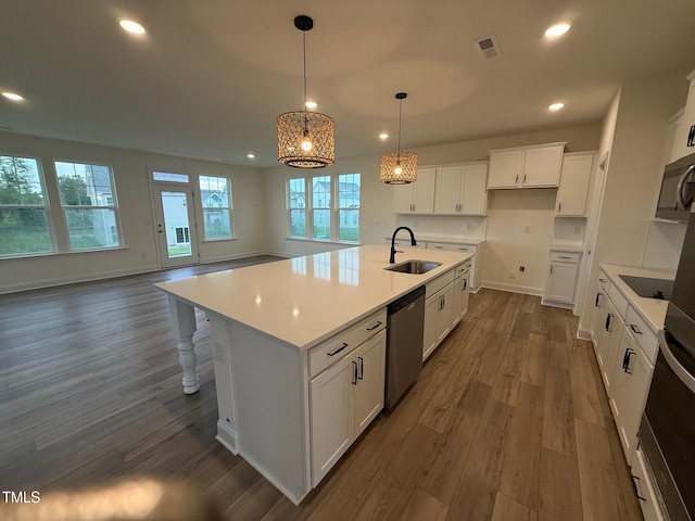 1024 Channel Drop, Zebulon, NC 27597 - kitchen featuring stainless steel appliances, dark wood-style flooring, recessed lighting, a kitchen island with sink, and white cabinetry