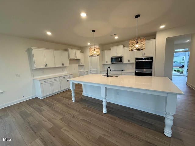 1024 Channel Drop, Zebulon, NC 27597 - kitchen featuring stainless steel appliances, white cabinets, a spacious island, dark wood-type flooring, and recessed lighting