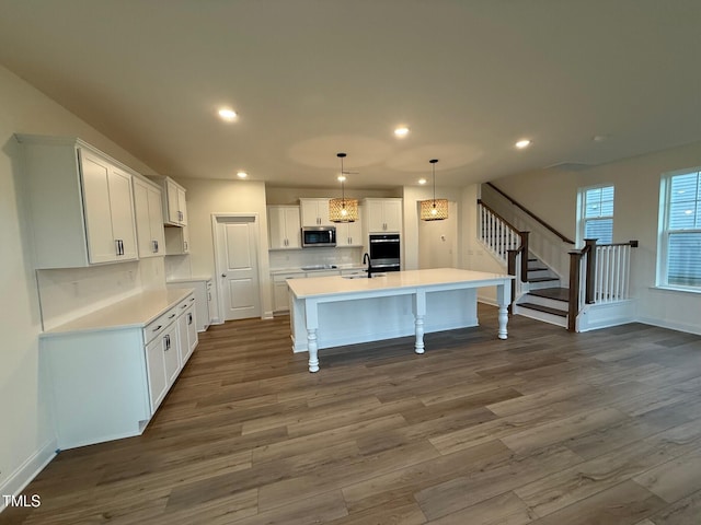 1024 Channel Drop, Zebulon, NC 27597 - kitchen featuring appliances with stainless steel finishes, dark wood-style flooring, a kitchen island with sink, white cabinets, and recessed lighting
