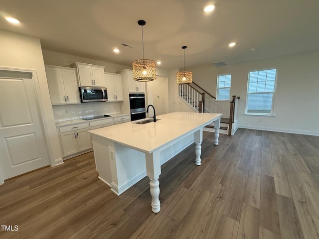 1024 Channel Drop, Zebulon, NC 27597 - kitchen with stainless steel microwave, black electric cooktop, decorative backsplash, dark wood-style floors, and recessed lighting