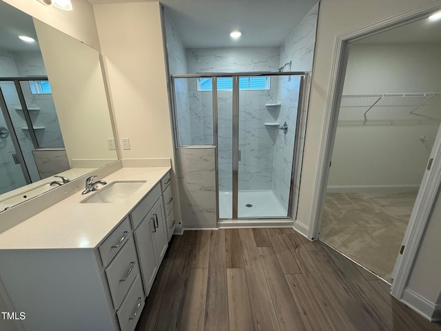 1024 Channel Drop, Zebulon, NC 27597 - bathroom featuring a marble finish shower, vanity, wood finished floors, a spacious closet, and recessed lighting