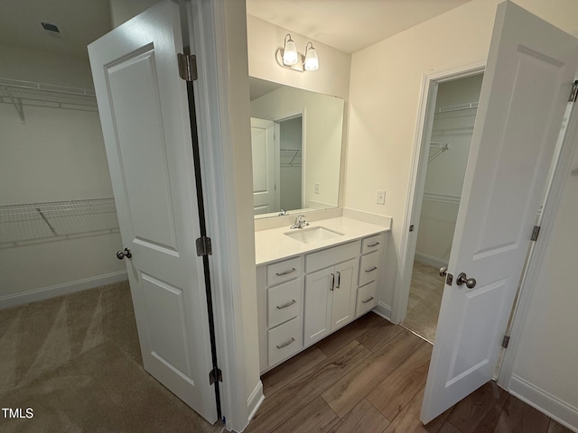 1024 Channel Drop, Zebulon, NC 27597 - bathroom featuring vanity, a spacious closet, and wood finished floors