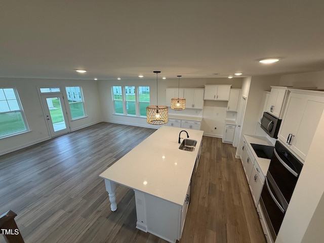 1024 Channel Drop, Zebulon, NC 27597 - kitchen with stainless steel microwave, dark wood-style flooring, recessed lighting, a center island with sink, and white cabinetry