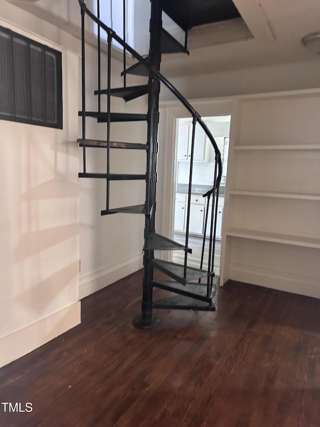 stairway featuring baseboards and wood finished floors
