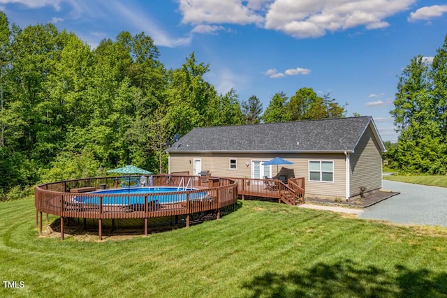 view of swimming pool featuring a wooden deck and a yard