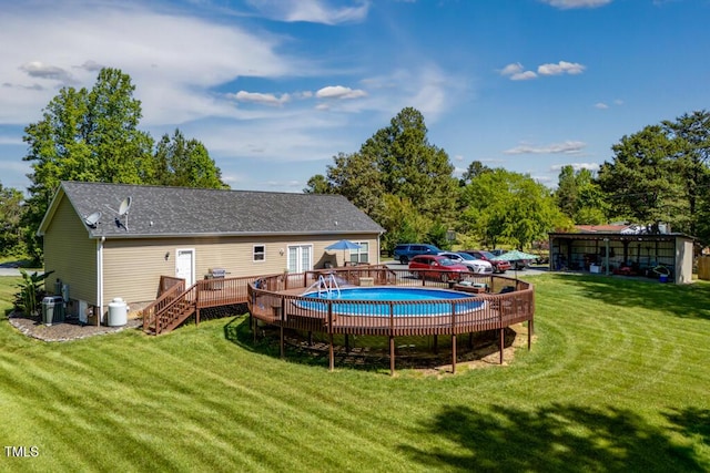 view of swimming pool featuring a deck and a lawn