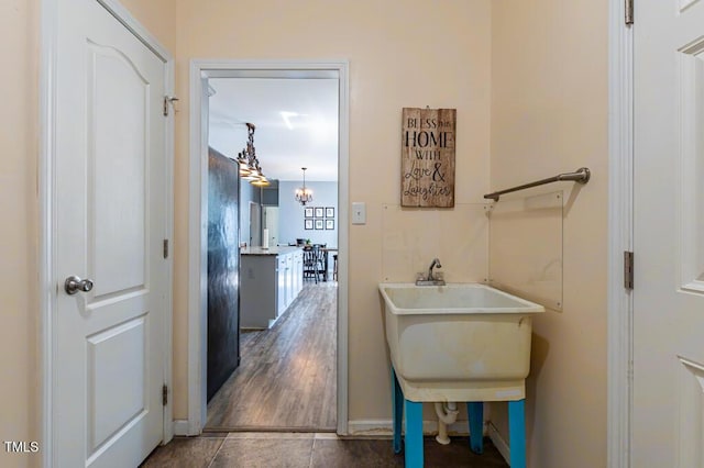 hall with baseboards, a chandelier, and tile patterned floors