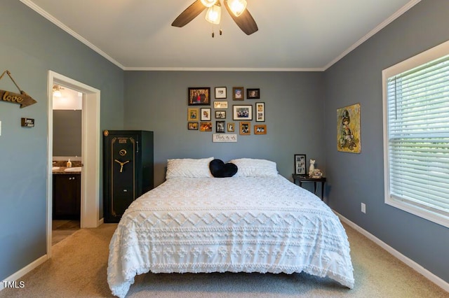 bedroom with carpet floors, crown molding, baseboards, ensuite bathroom, and a ceiling fan